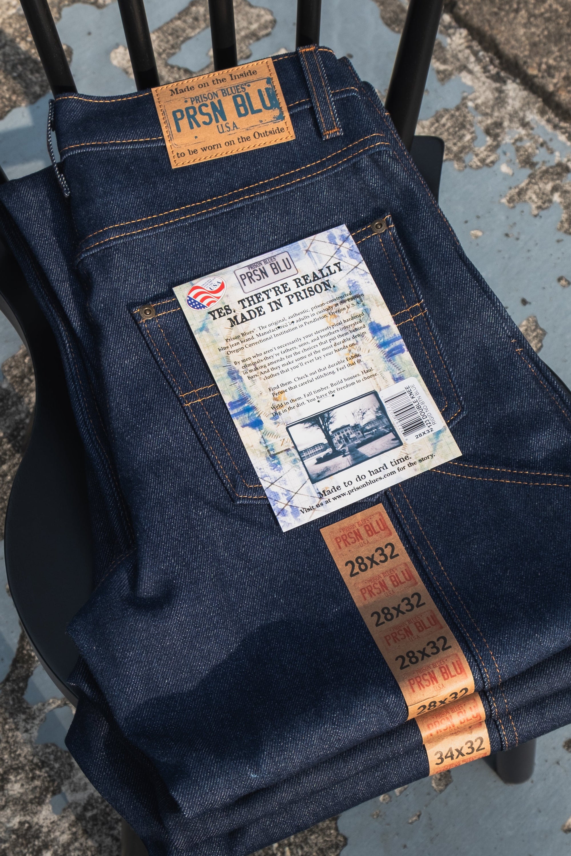 PRISON BLUES USA rigid raw denim jeans stack with leather patch and size tags, authentic American workwear denim available in Singapore
